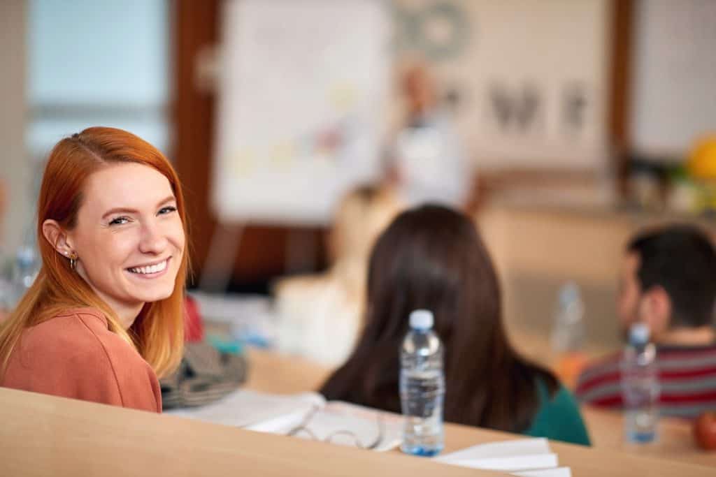 Young female student in a classroom looking towards the camera