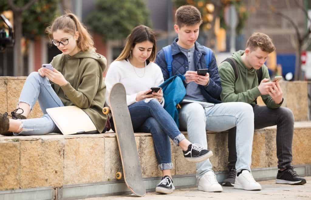 Teenagers using their smartphones